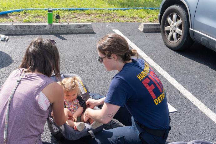 Employees checking car seat with child