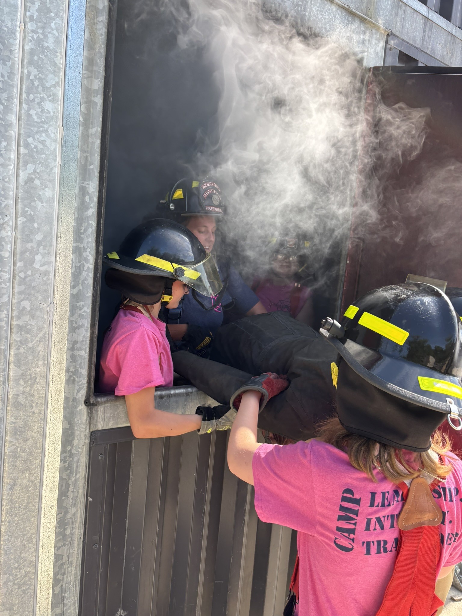 Campers working together to rescue a dummy out of the training building. 