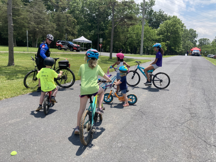 Bike police man talks with children on bikes about road safety