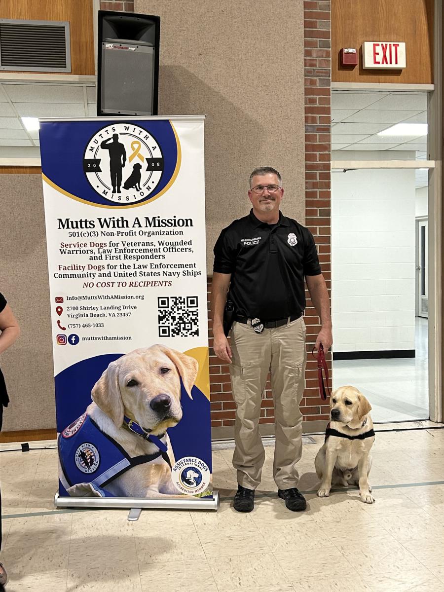 Detective Miller standing with facility dog Hudson