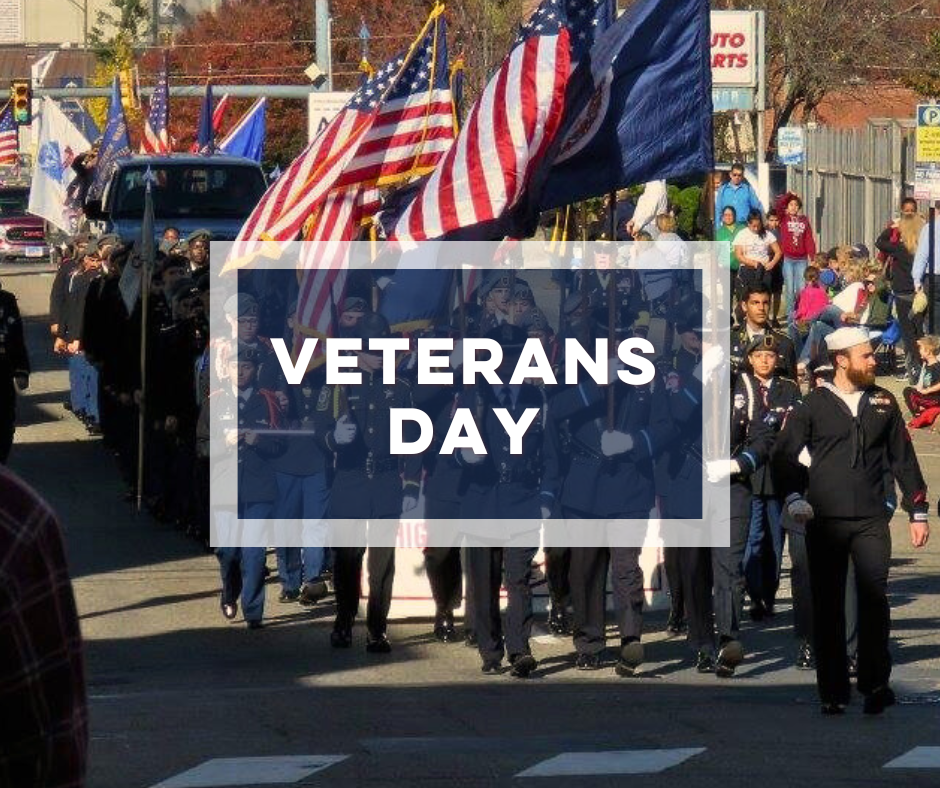 Bold text Veterans Day over parade with Veterans walking