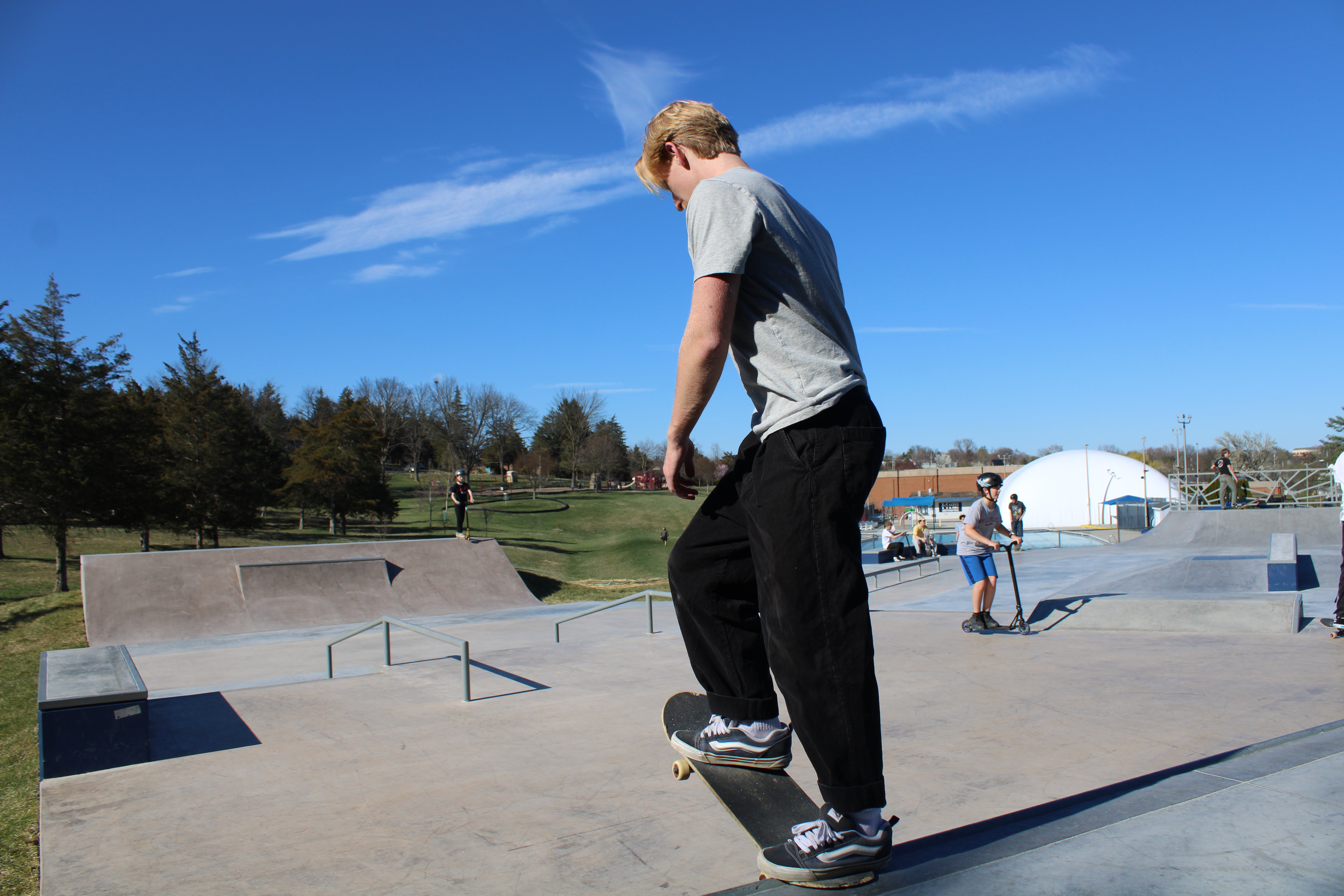 Man about to drop in on his skateboard down a ramp.