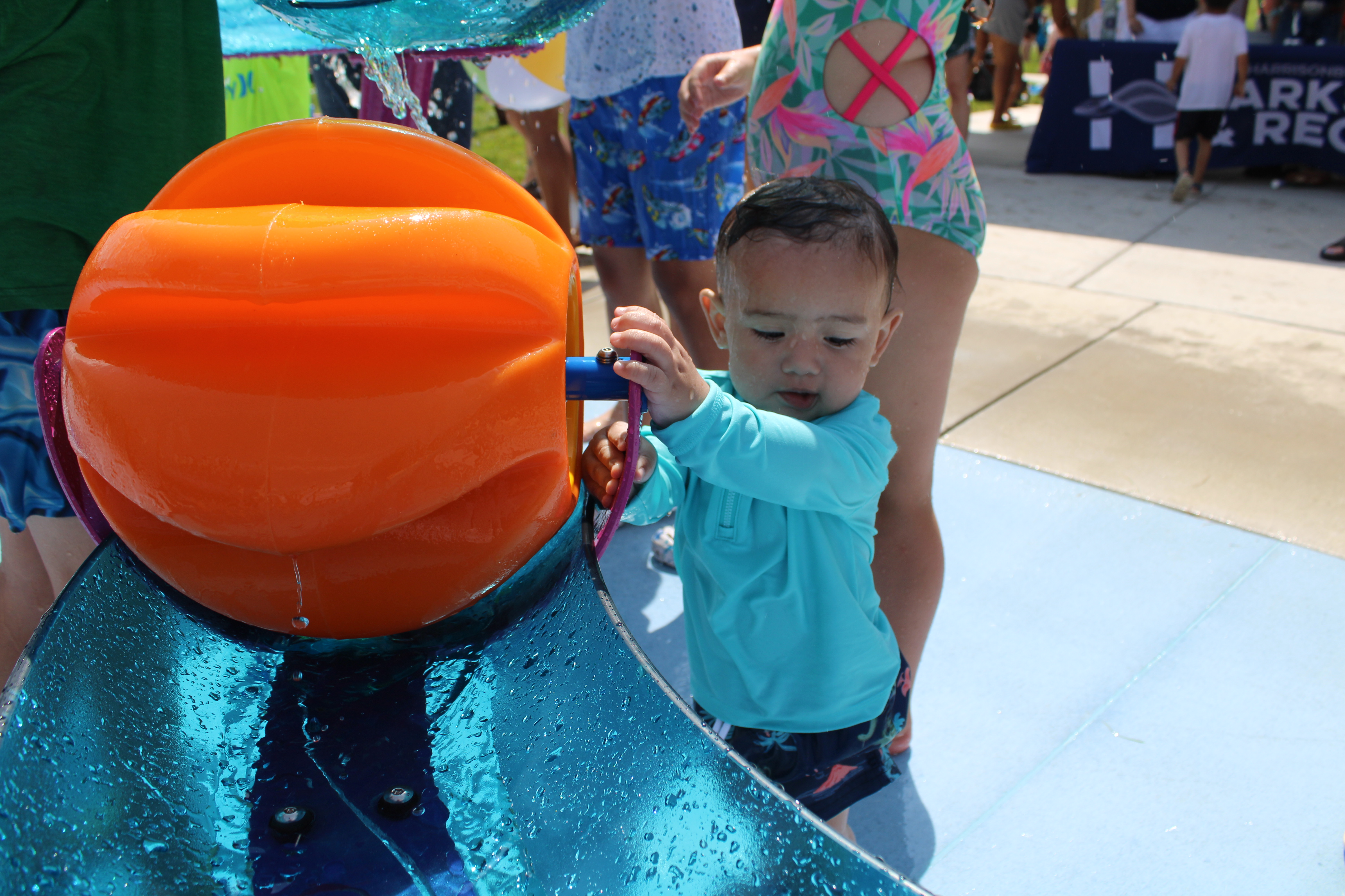 Image of a young child playing with a water feature at the spraygrounds.